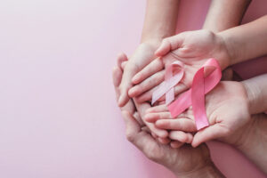 three generations of women holding the breast cancer awareness ribbon